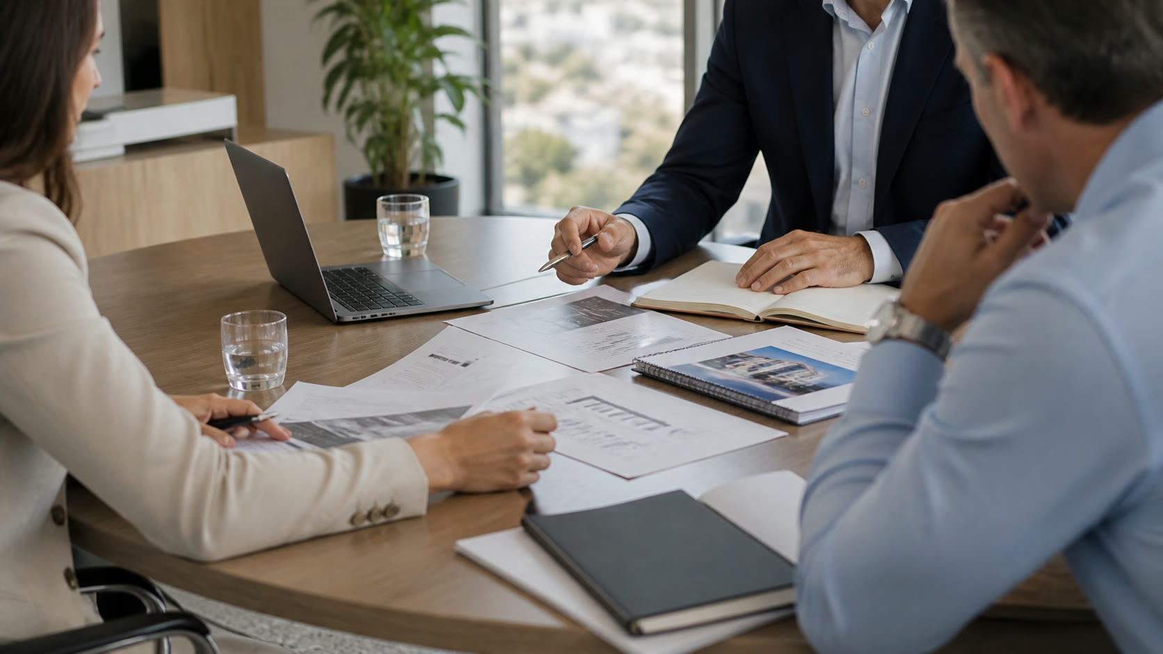 Three advisers reviewing acquisition documents around a meeting table, with faces cropped or turned away